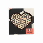Hart van witte chocolade met geometrische print in een donkere doos