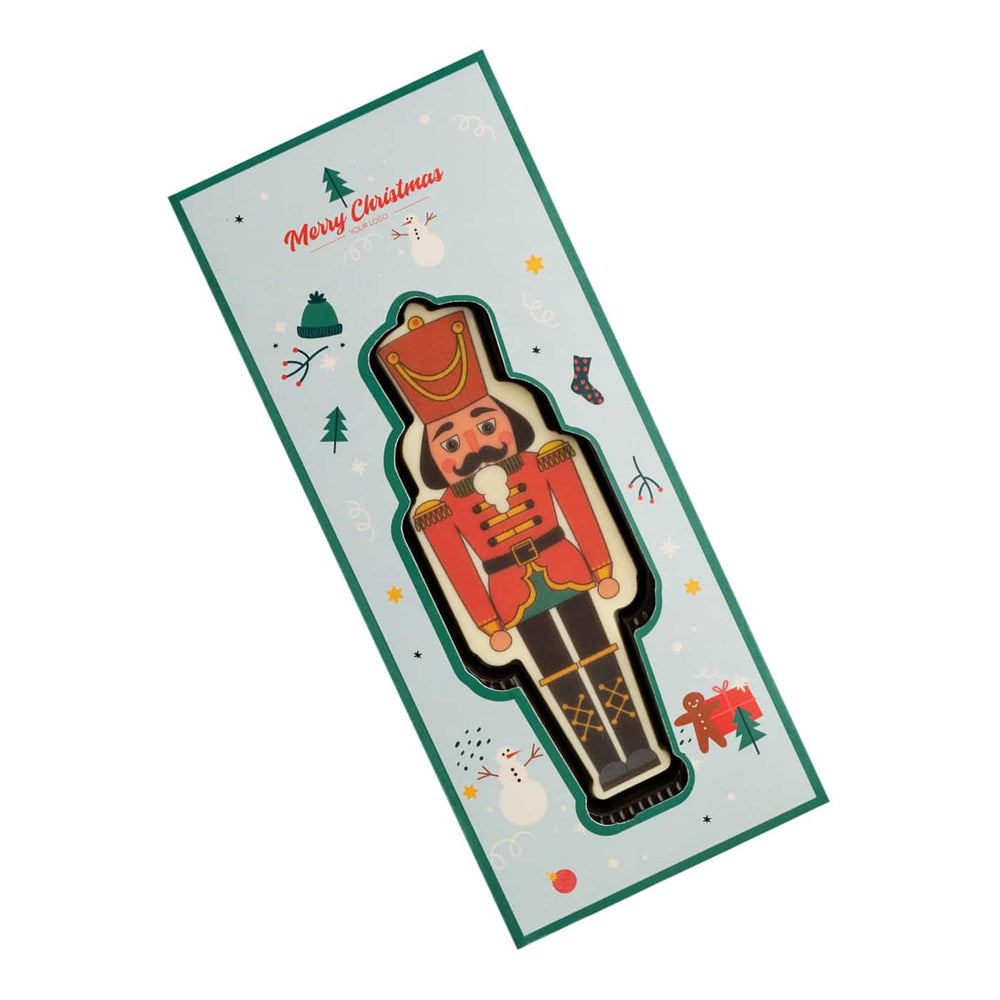 Notenkraker van witte chocolade in rood en groen bedrukt, in een lange kerstdoos