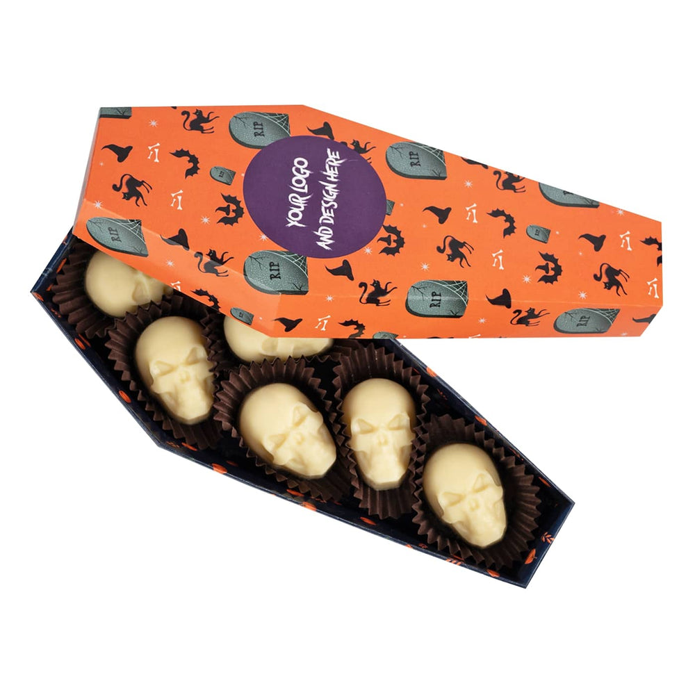 Oranje doos in de vorm van een doodskist met schedelpralines van witte chocolade