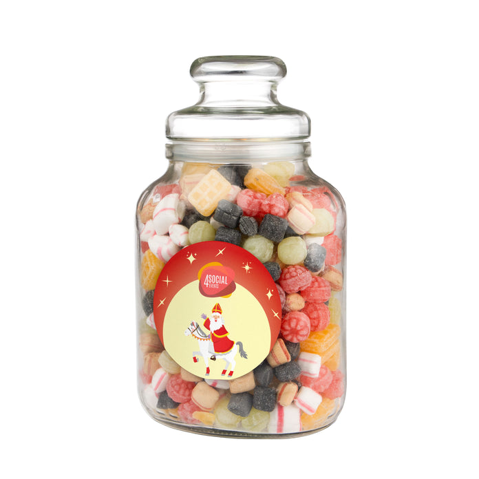 Hoge nostalgische glazen snoeppot gevuld met snoep, met een ronde sticker met logo op de voorzijde: Oud Hollandse mix