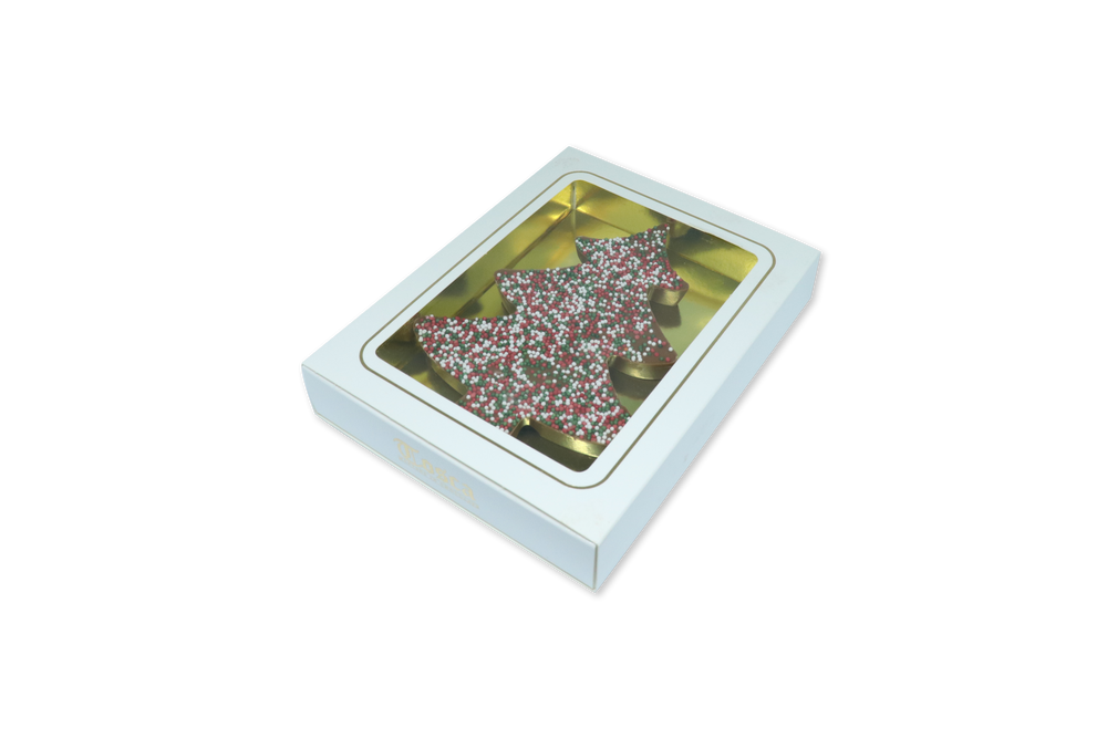 Chocolade kerstboom met kleurrijke sprinkles in vensterdoos, gezien door het venster