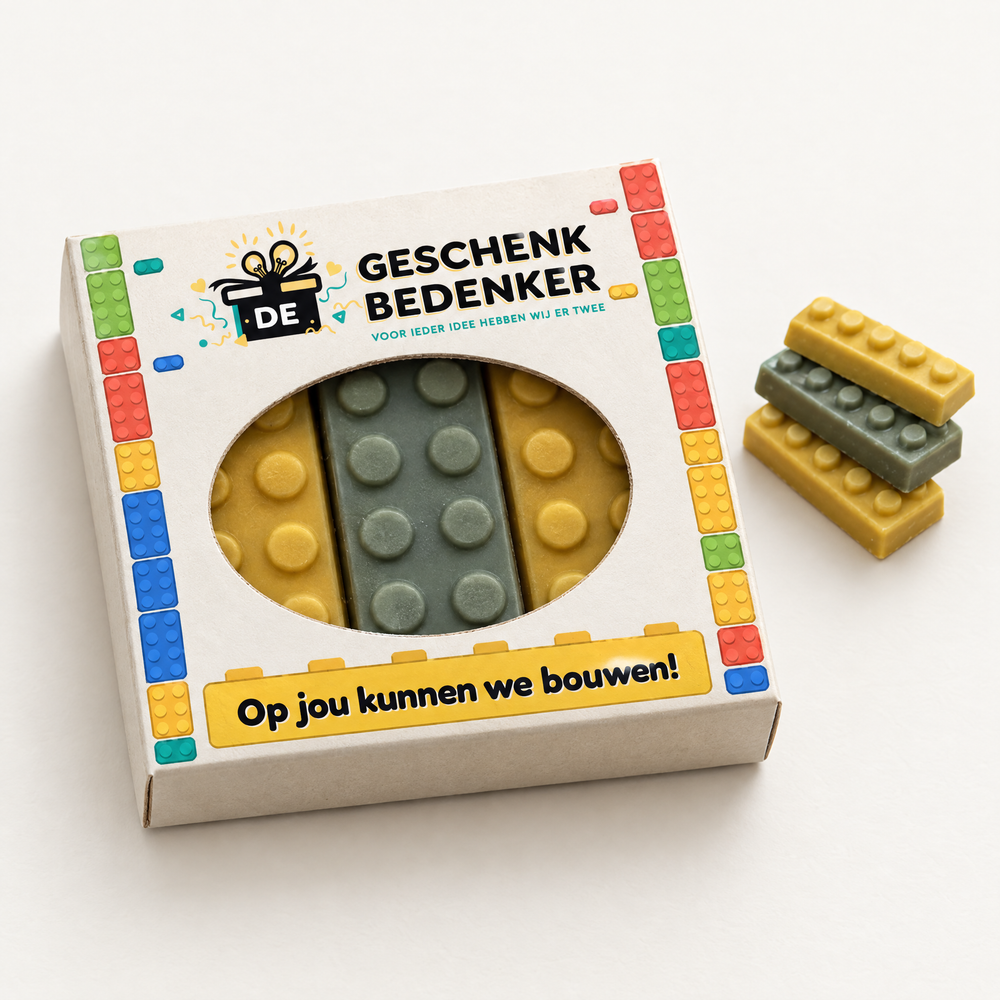 Vierkant bedrukt doosje met ovaal venster en drie chocolade bouwstenen in lego-stijl, met tekst Op jou kunnen we bouwen