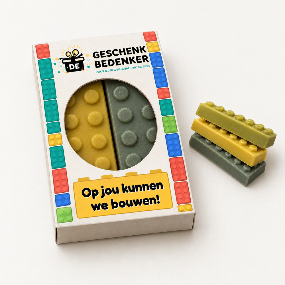 Bedrukt doosje met ovaal venster en twee chocolade bouwstenen in lego-stijl, met tekst Op jou kunnen we bouwen