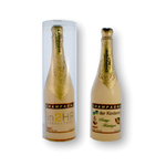 Twee champagneflessen van witte chocolade met goudfolie en voorbeeldlogo op het etiket, één in transparante koker