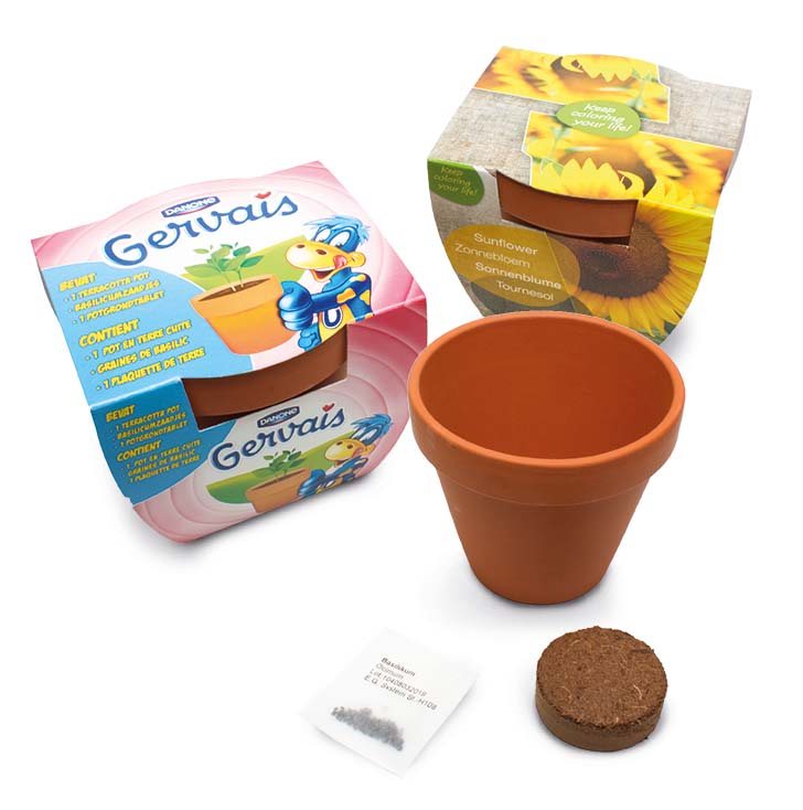 Grote terracotta kweekpot met kokostablet en zaadzakje, naast bedrukte wikkels als voorbeeld