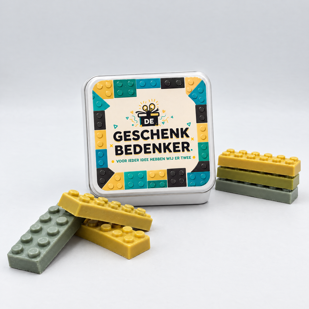 Wit vierkant blik met bedrukt deksel in lego-stijl en logo, naast gestapelde chocolade bouwstenen