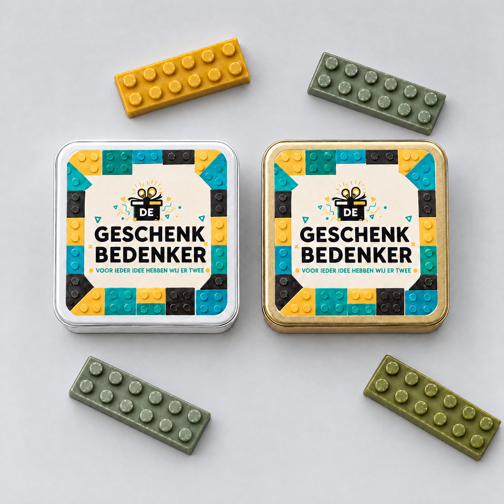 Wit en goudkleurig blik met bedrukt deksel van bovenaf, met losse chocolade bouwstenen eromheen
