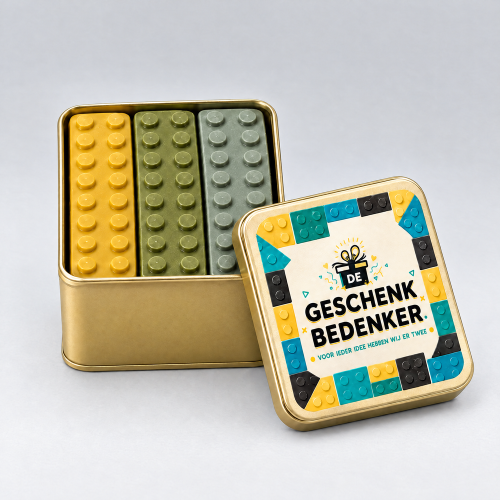 Geopend goudkleurig blik gevuld met chocolade bouwstenen in lego-stijl, bedrukt deksel ertegenaan