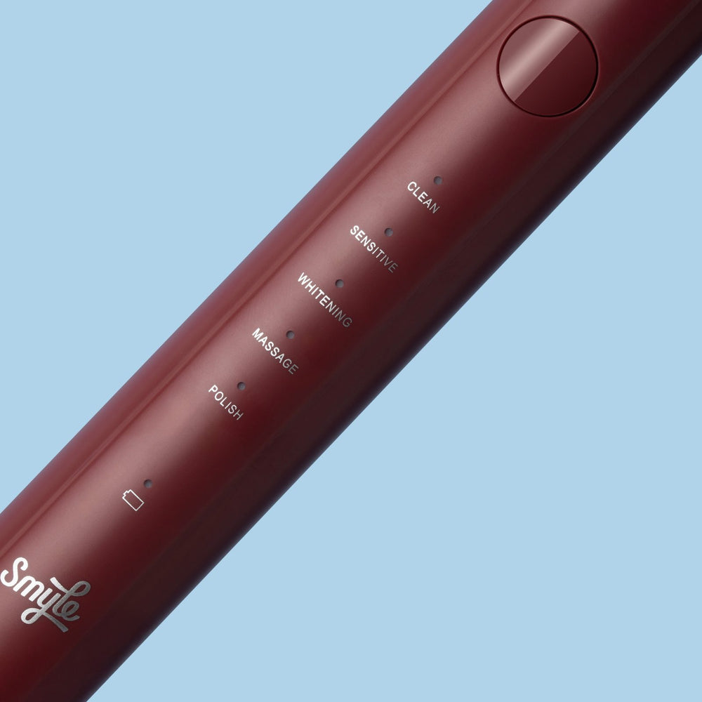 Close-up van de bordeauxrode Smyle elektrische tandenborstel